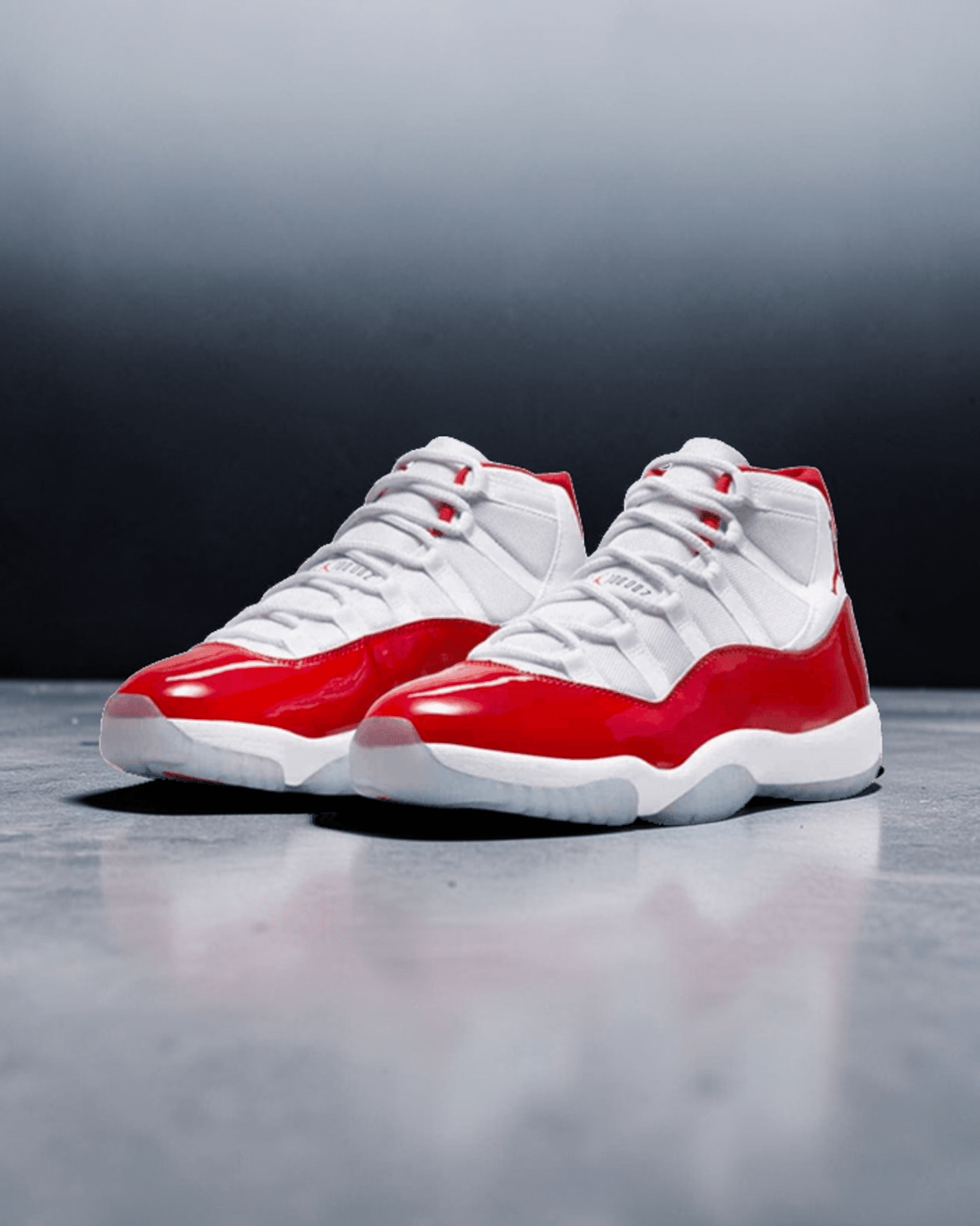 Plugmarket Air Jordan 11 Retro Cherry sneakers with white mesh uppers and patent leather red overlays.