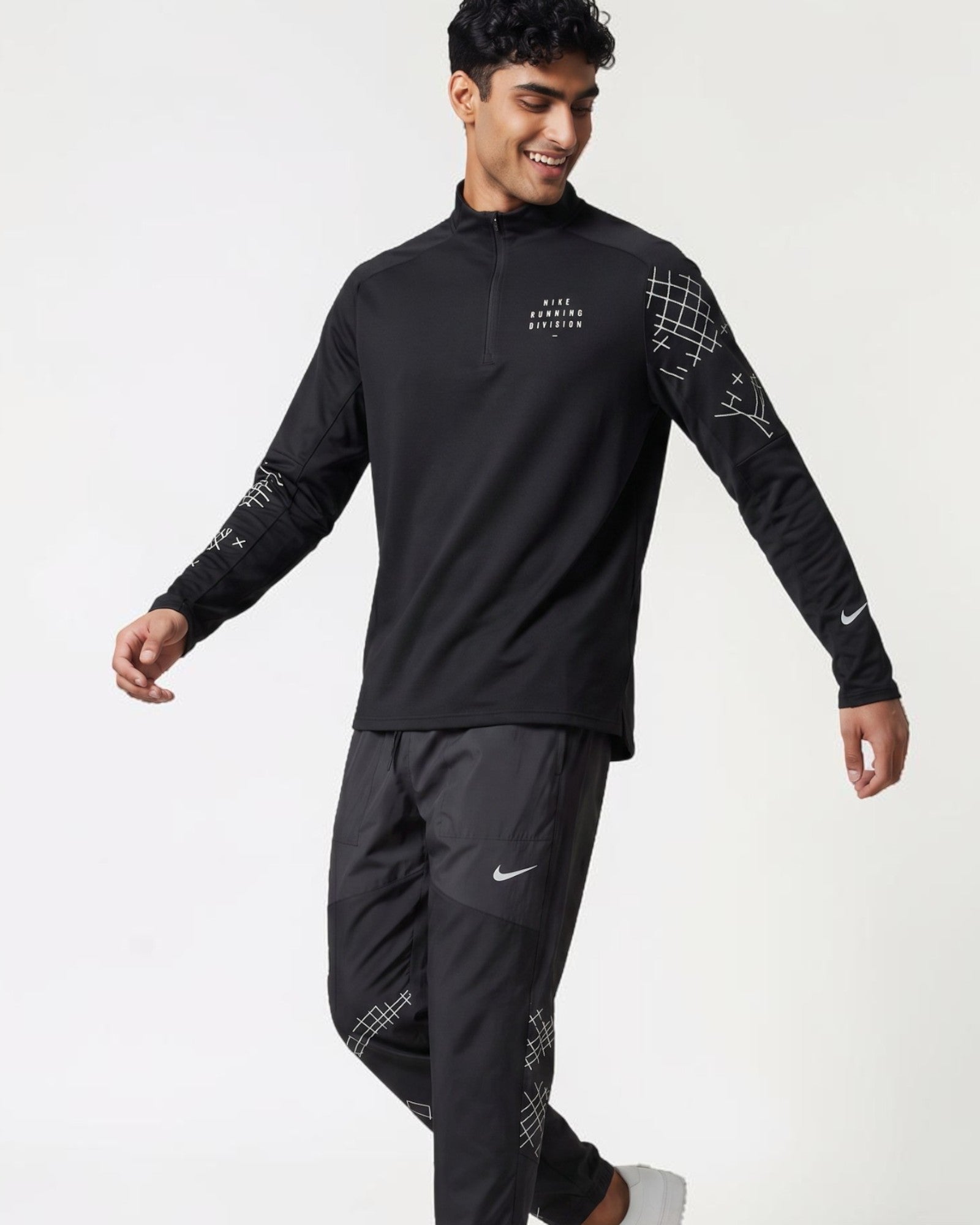 Plugmarket black running set with quarter zip top and pants. Features graphic print details and Nike swoosh.